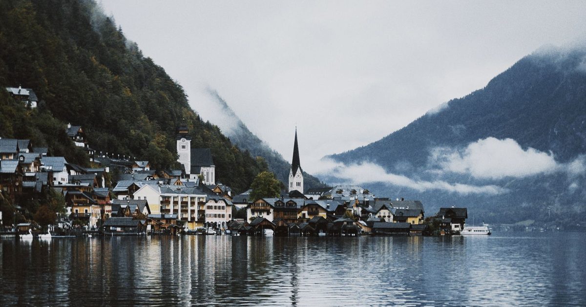 Hallstatt village by its lake among misty mountains
