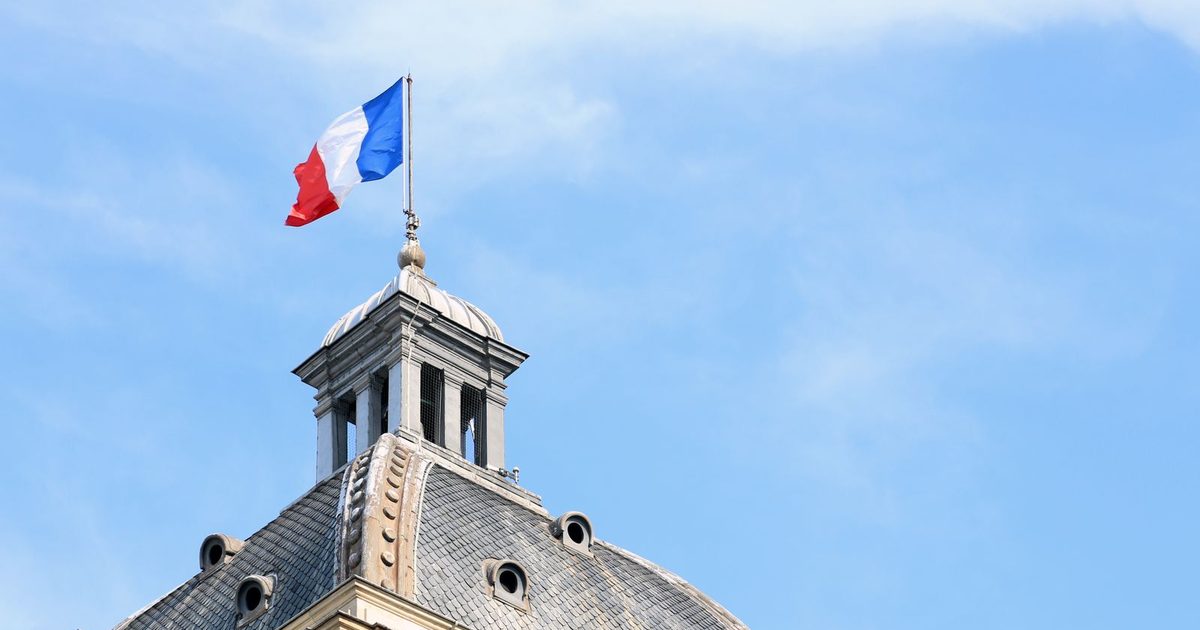 The French flag on the dome of a historic building in Paris